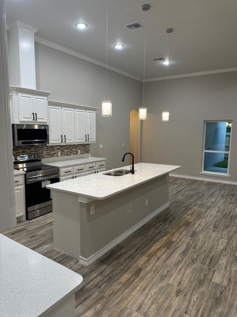 kitchen featuring sink, dark wood-type flooring, a kitchen island with sink, white cabinets, and appliances with stainless steel finishes