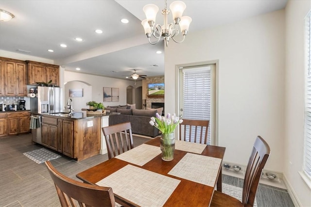 1805 Bay Landing Dr, Portland, TX 78374 - dining room featuring arched walkways, recessed lighting, ceiling fan, a fireplace, and a chandelier