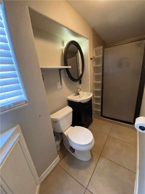 bathroom featuring tile patterned flooring, vanity, toilet, and an enclosed shower