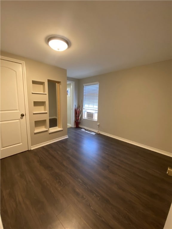 unfurnished living room with dark hardwood / wood-style flooring and a baseboard radiator