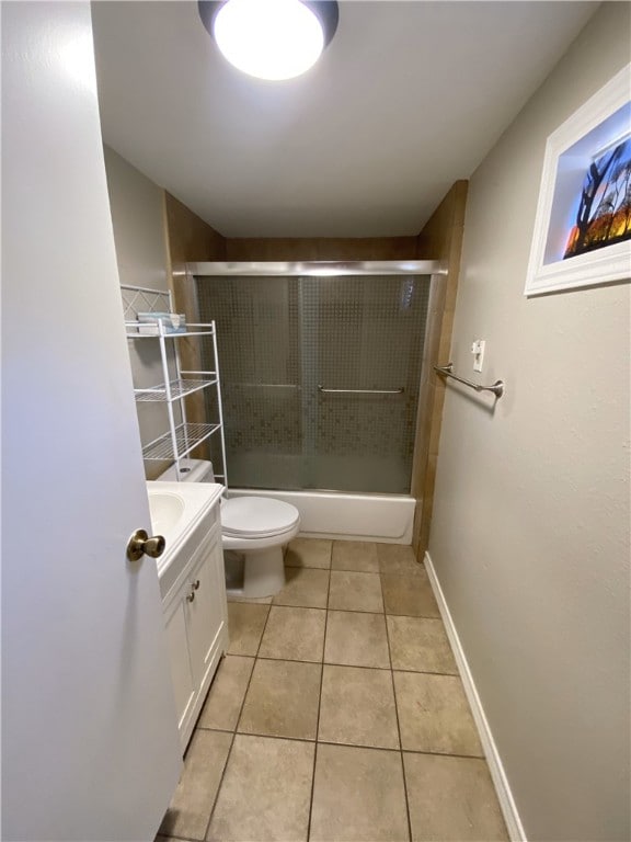 full bathroom featuring toilet, tile patterned flooring, vanity, and combined bath / shower with glass door