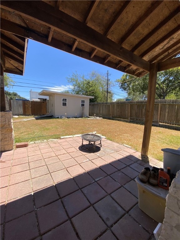 1038 Dorthy Dr, Corpus Christi, TX 78412 - fenced backyard featuring a patio, an outbuilding, and a fire pit