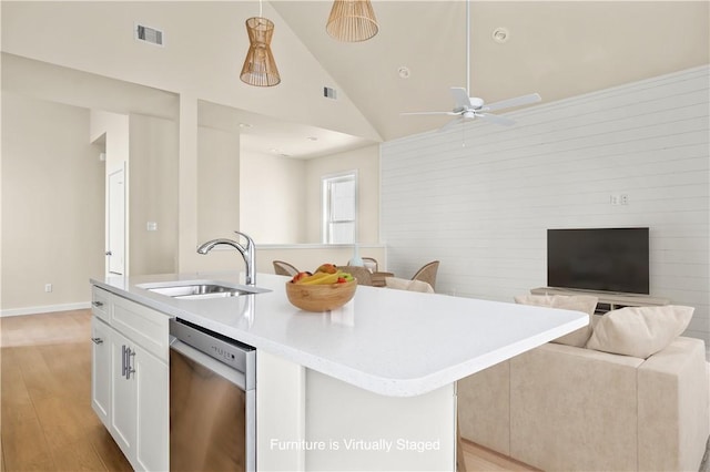 kitchen with white cabinetry, an island with sink, a sink, dishwasher, and open floor plan