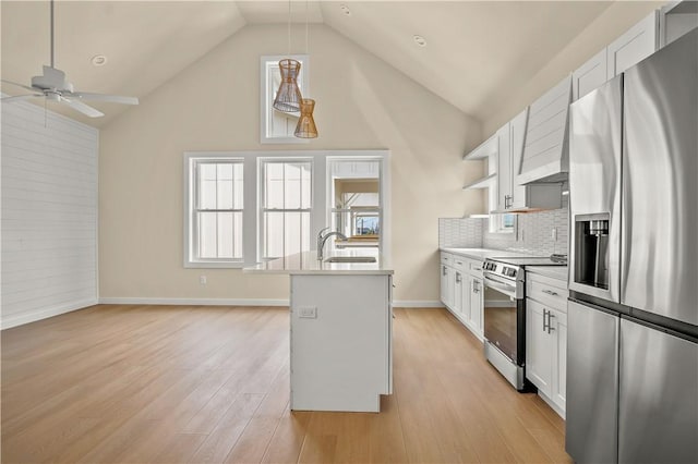 kitchen featuring light wood finished floors, plenty of natural light, appliances with stainless steel finishes, and ceiling fan