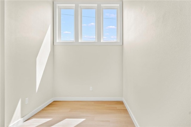 spare room with light wood-type flooring and baseboards