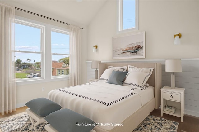 bedroom with wood finished floors and vaulted ceiling