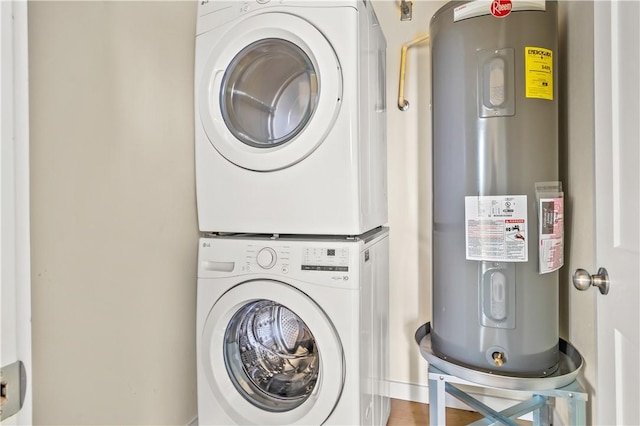 clothes washing area featuring laundry area, electric water heater, and stacked washer / drying machine