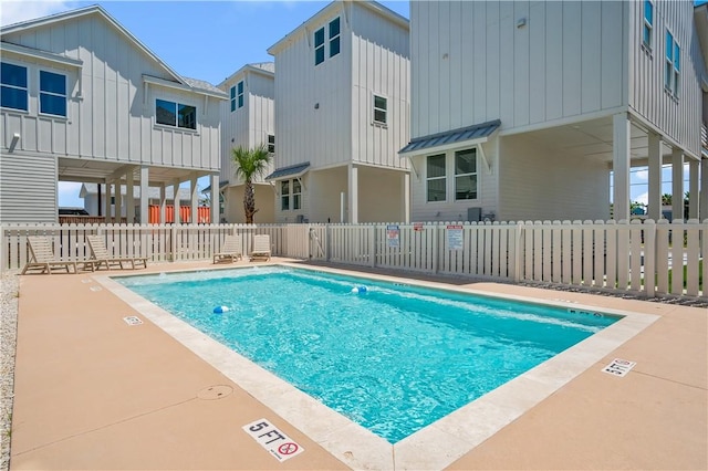 community pool with a patio and fence