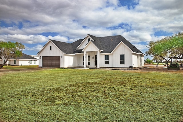 modern inspired farmhouse with a porch, a garage, and a front lawn