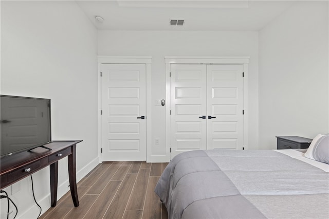 bedroom featuring wood-type flooring and two closets