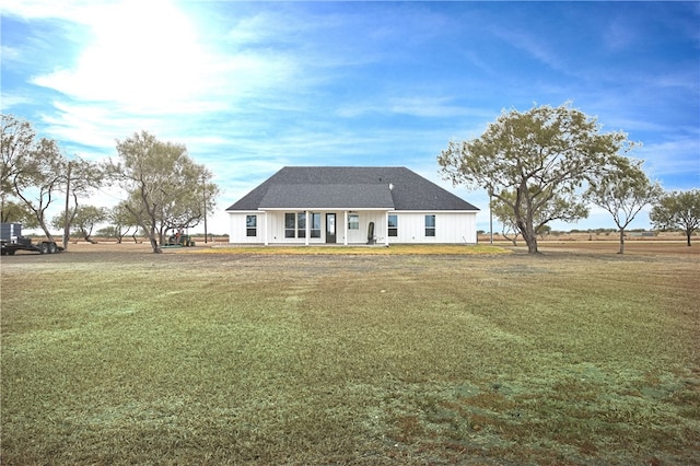 rear view of property featuring a porch and a yard