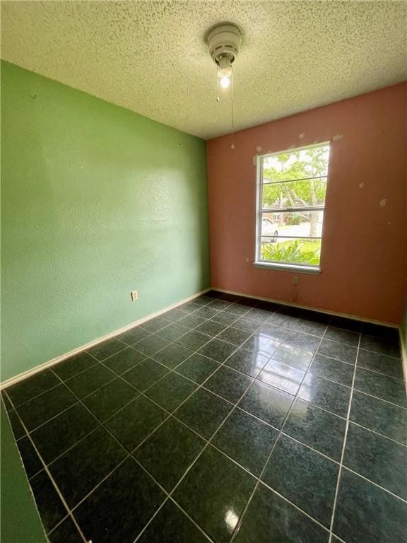 2418 Vialoux Dr, Corpus Christi, TX 78418 - unfurnished room with baseboards, a textured ceiling, and dark tile patterned flooring