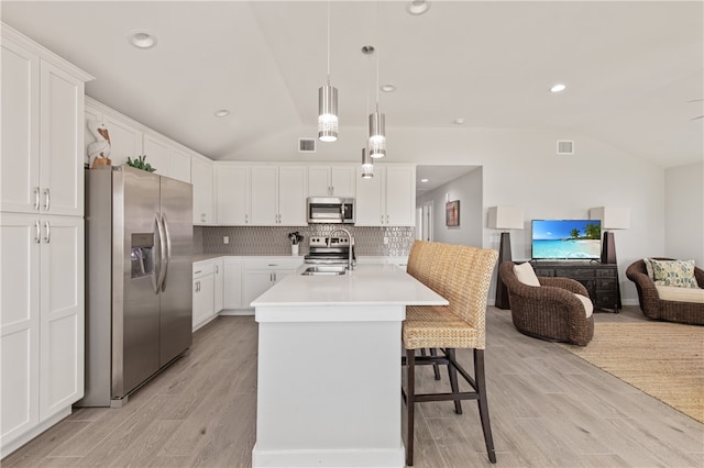 kitchen with white cabinetry, stainless steel appliances, lofted ceiling, and pendant lighting