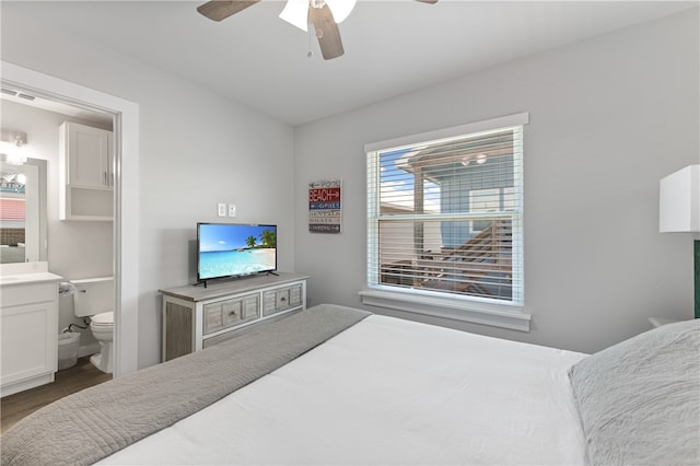 bedroom with ceiling fan, connected bathroom, and wood-type flooring