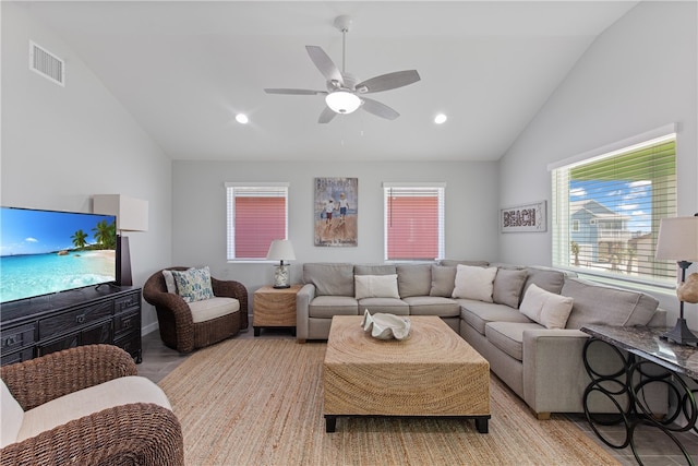 living room featuring light hardwood / wood-style floors, ceiling fan, and high vaulted ceiling