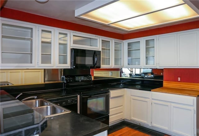 4454 Ocean Dr Unit 4, Corpus Christi, TX 78412 - kitchen with black appliances, white cabinetry, glass insert cabinets, dark wood-style floors, and dark countertops