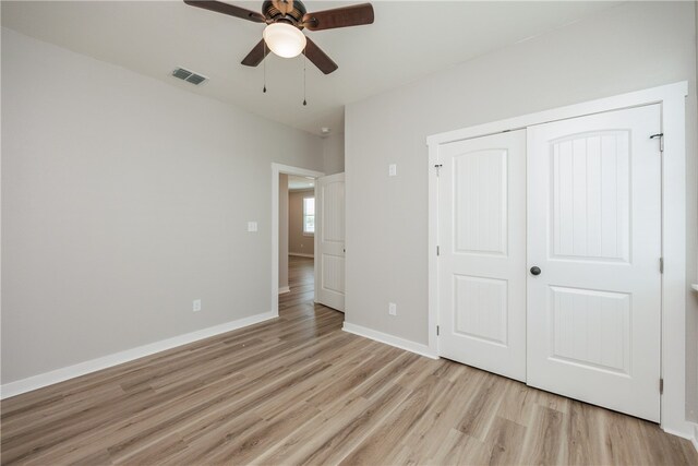 unfurnished bedroom with a closet, light wood-type flooring, and ceiling fan