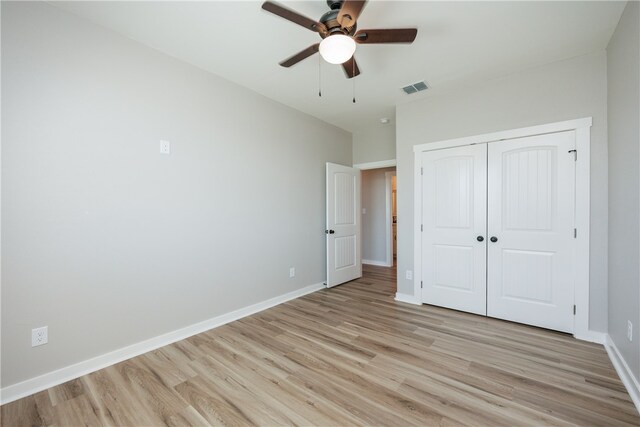 unfurnished bedroom featuring light hardwood / wood-style flooring, ceiling fan, and a closet