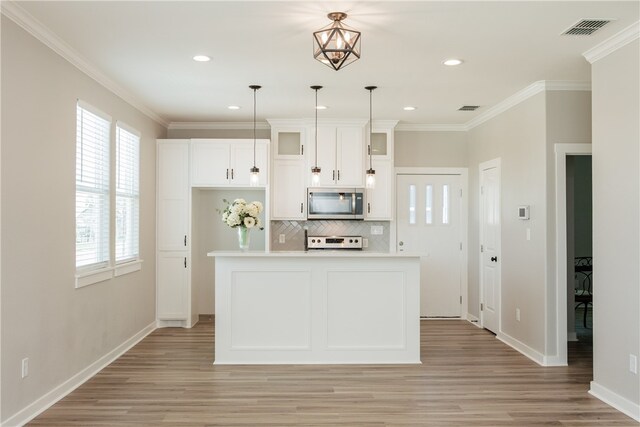 kitchen with hanging light fixtures, plenty of natural light, light hardwood / wood-style flooring, and a kitchen island