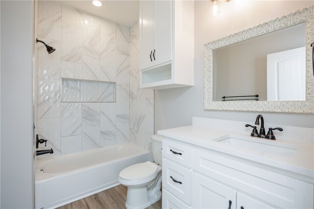 full bathroom featuring wood-type flooring, toilet, vanity, and tiled shower / bath