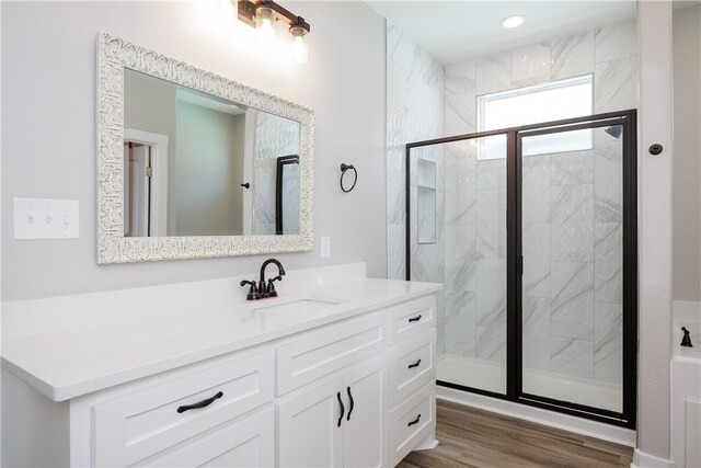 bathroom featuring wood-type flooring, vanity, and a shower with door