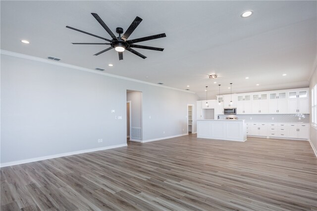 unfurnished living room with ornamental molding, light hardwood / wood-style floors, and ceiling fan