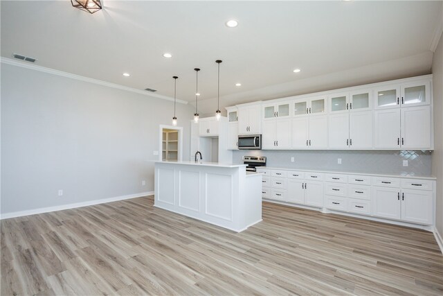 kitchen featuring ornamental molding, stainless steel appliances, white cabinetry, hanging light fixtures, and light hardwood / wood-style flooring