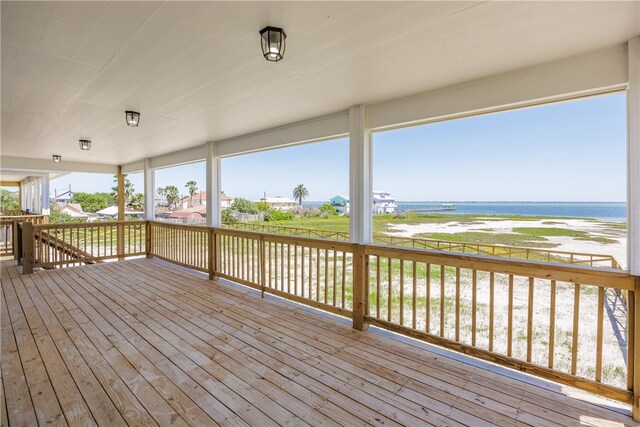 deck featuring a beach view and a water view