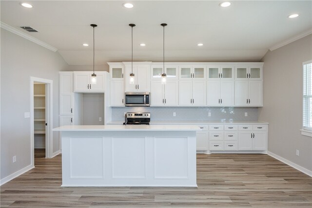 kitchen with a center island with sink, pendant lighting, and appliances with stainless steel finishes