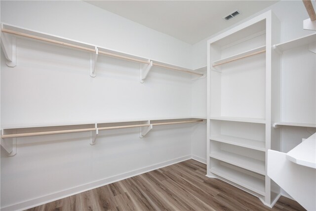 walk in closet with hardwood / wood-style flooring