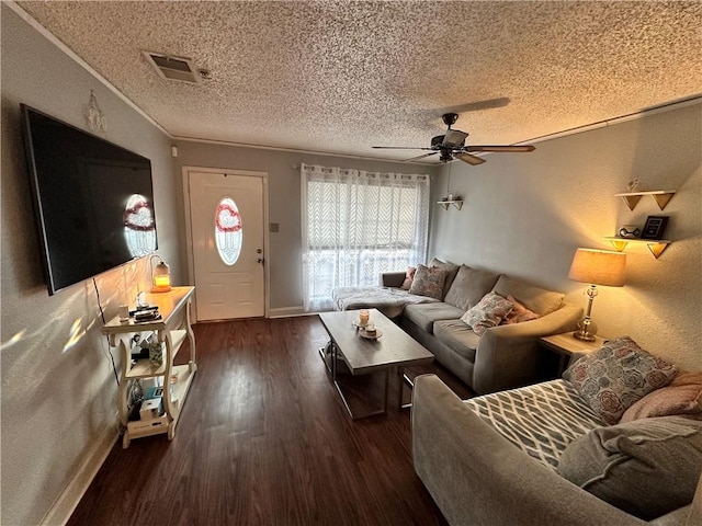 living room featuring ceiling fan, crown molding, dark wood-type flooring, and a textured ceiling