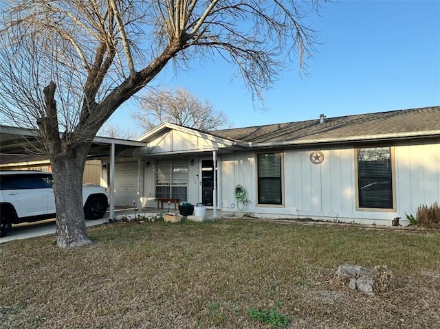 ranch-style house featuring a front yard, a carport, and covered porch