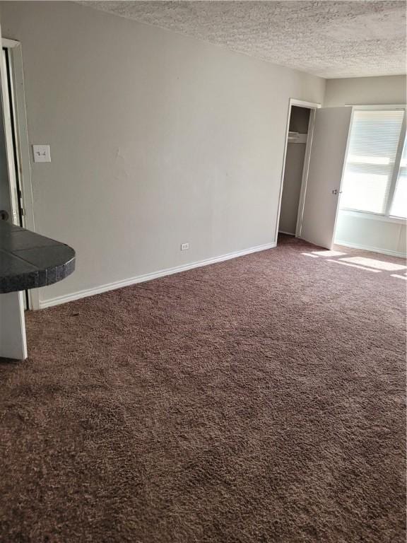 interior space with dark colored carpet and a textured ceiling