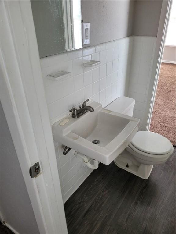 bathroom with sink, wood-type flooring, toilet, and tile walls