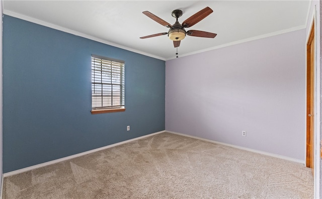 carpeted spare room with crown molding, a ceiling fan, and baseboards
