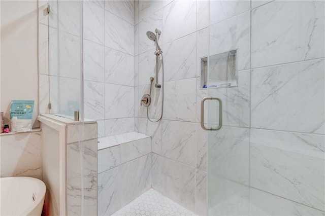 bathroom with a freestanding tub and a shower stall