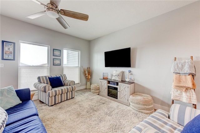 living room with a ceiling fan and baseboards