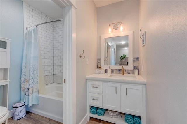 full bath featuring toilet, wood finished floors, shower / bath combination with curtain, and vanity