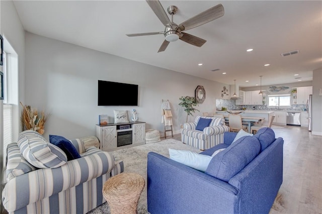 living area featuring ceiling fan, recessed lighting, visible vents, and light wood-style floors