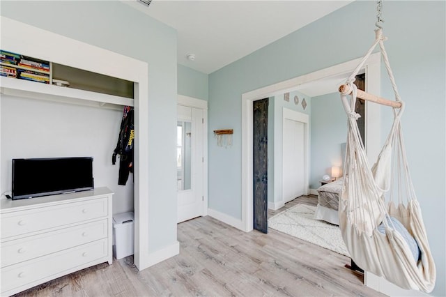 bedroom featuring baseboards and light wood finished floors