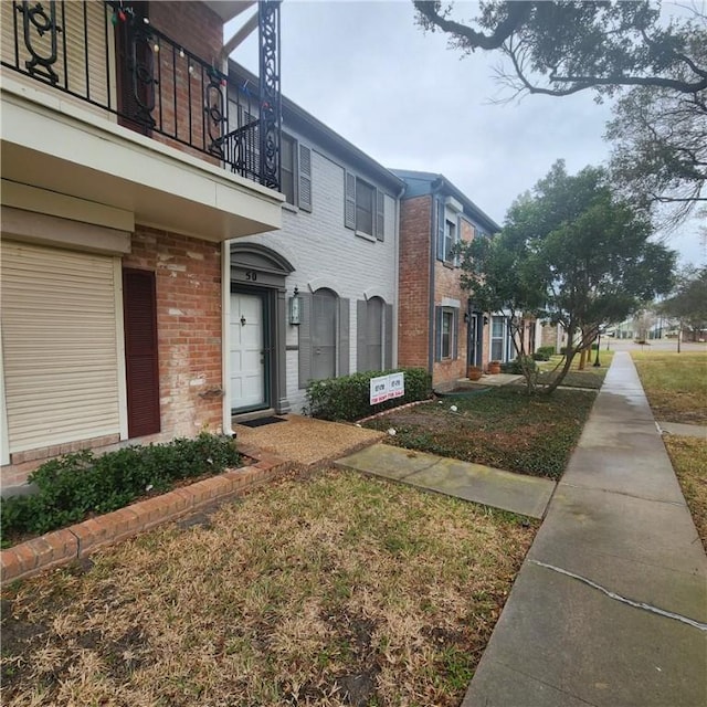 view of home's exterior featuring brick siding and a balcony