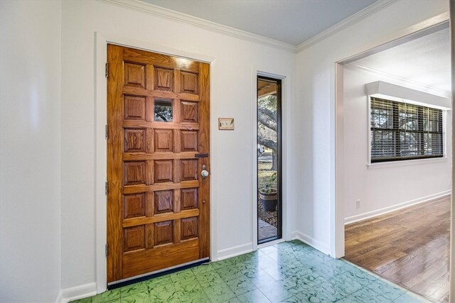 foyer entrance featuring ornamental molding, tile patterned floors, and baseboards