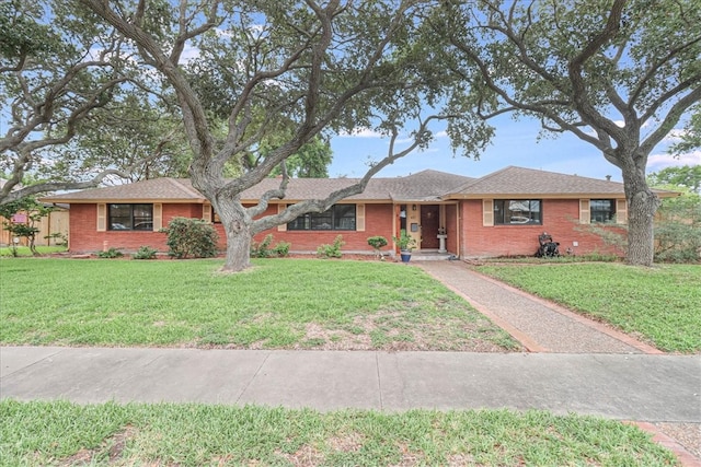 single story home featuring brick siding and a front lawn