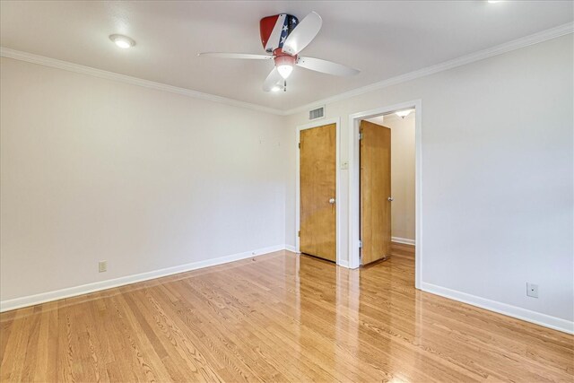 unfurnished room featuring baseboards, light wood finished floors, and crown molding