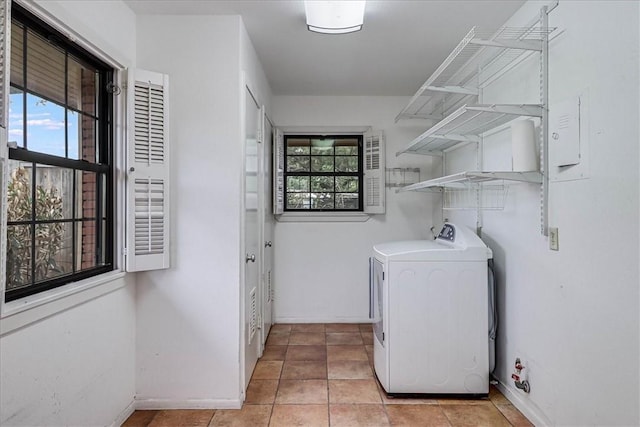 washroom featuring laundry area, plenty of natural light, washing machine and dryer, and baseboards