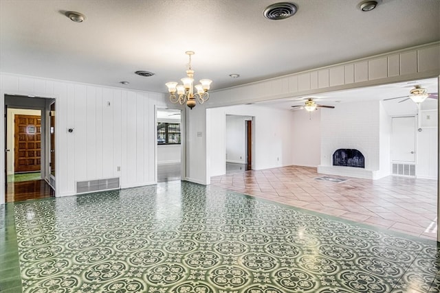 interior space featuring a brick fireplace, visible vents, and ceiling fan with notable chandelier