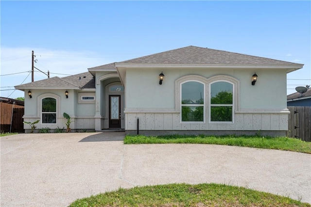 1706 Kentucky Derby Dr, Corpus Christi, TX 78417 - view of front facade with stucco siding, fence, and roof with shingles