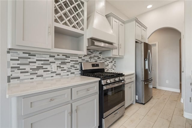 1706 Kentucky Derby Dr, Corpus Christi, TX 78417 - kitchen featuring decorative backsplash, stainless steel appliances, arched walkways, custom range hood, and exhaust hood