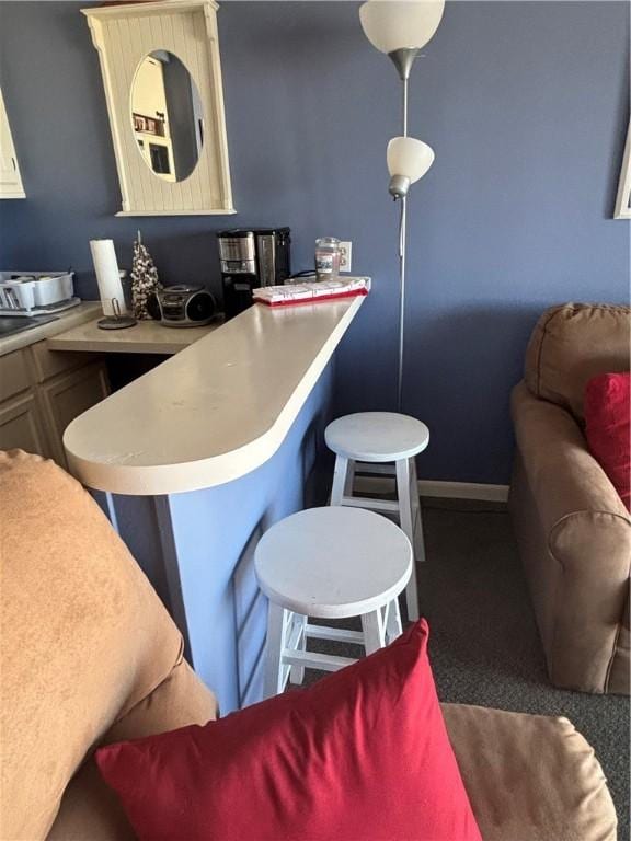 3938 Surfside Blvd Unit 2235, Corpus Christi, TX 78402 - kitchen featuring a breakfast bar area, light countertops, carpet floors, and a peninsula