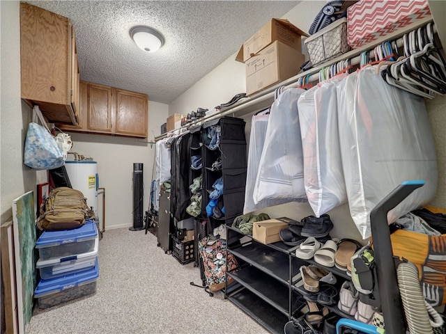 spacious closet featuring light colored carpet and water heater